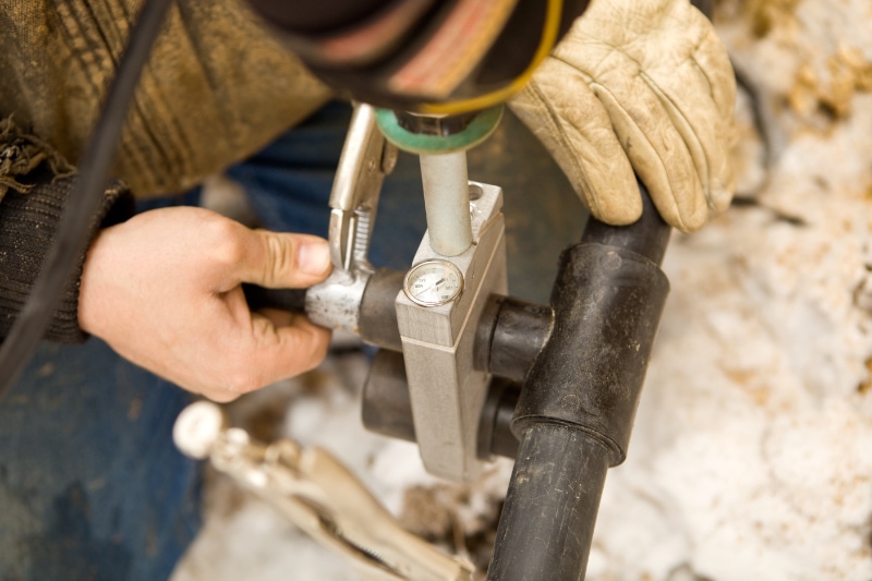 Two Workers Join Residential Geothermal Heat Pump Heating/Cooling Pipe for use.